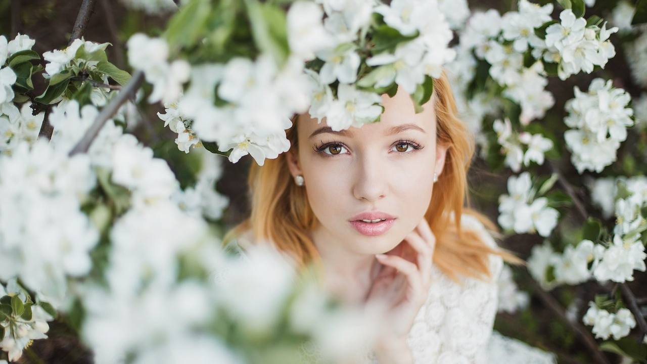 Donna circondata da fiori bianchi